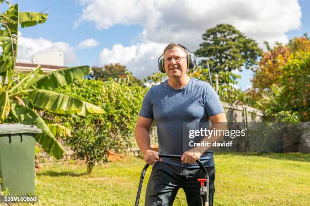 happy senior man mowing the lawn - lawn mowing stock pictures, royalty-free photos & images