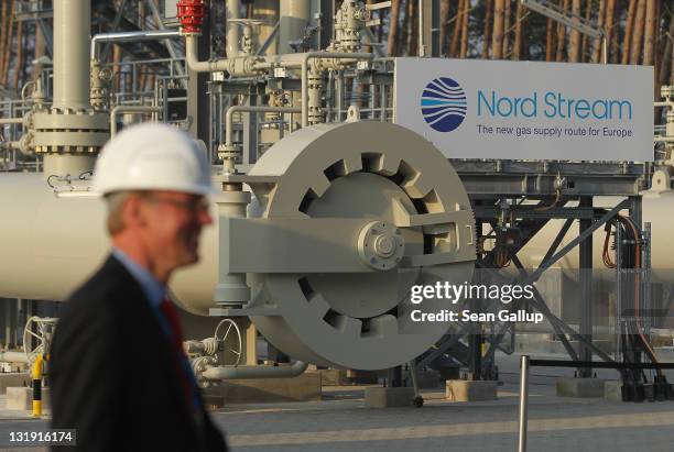 Man wearing a hard hat walks by the central facility where the Nord Stream Baltic Sea gas pipeline reaches western Europe following the pipeline's...