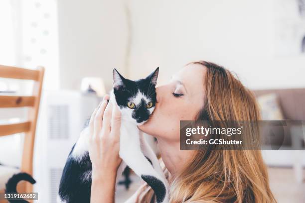 mujer caucásica juguetona con su gato - friends kissing cheeks fotografías e imágenes de stock