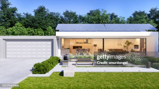 luxe villa exterieur met zonnepanelen op het dak. patio met zitplaatsen en tuin met bloemen en struiken. - window with view on garden stockfoto's en -beelden