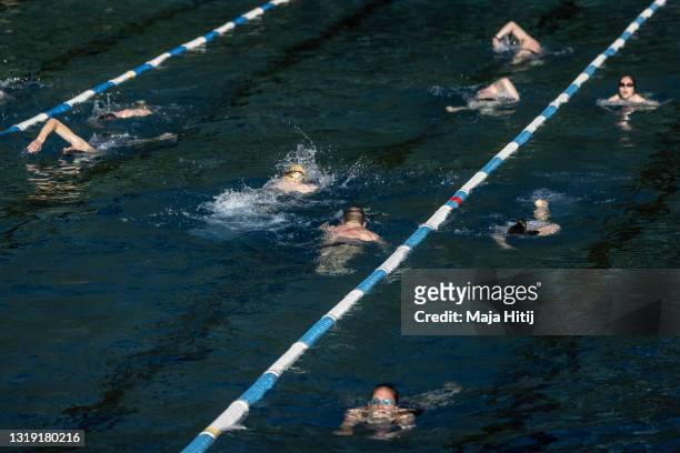 Swimmers exercise in an open air pool during the coronavirus pandemic on May 21, 2021 in Berlin, Germany. Authorities are easing lockdown measures...