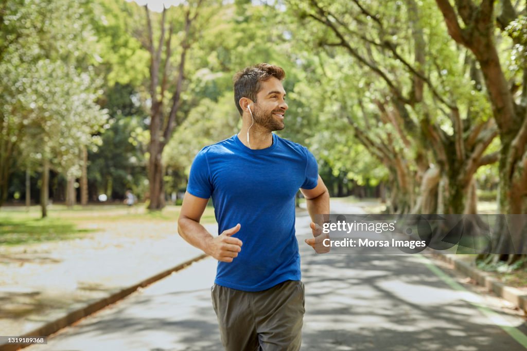 Medelålders man lyssnar på musik i parken