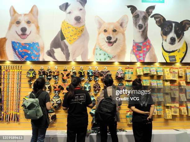 People shop for pet harnesses at the Fuzzyard booth during the 2021 Pet Fair Beijing at China National Convention Center on May 20, 2021 in Beijing,...