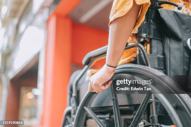 low angle close up asian indian beautiful woman with disability using wheelchair zebra crossing crossing road in the city - spinal cord injury stock pictures, royalty-free photos & images