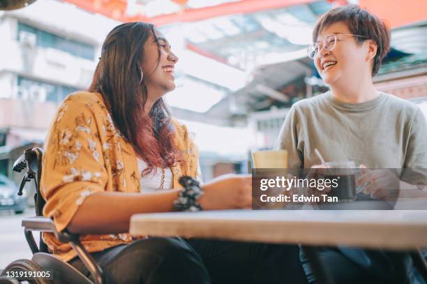 mulher indiana asiática com deficiência em cadeira de rodas desfrutando comida de rua em petaling rua com sua amiga chinesa - visual impairment - fotografias e filmes do acervo