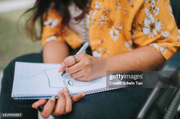 asian indian female with disability on wheelchair drawing on pad at city street - free hand sketch street stock pictures, royalty-free photos & images