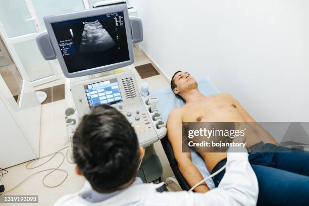 jeune patient masculin ayant l’examen d’ultrason de l’abdomen dans la clinique médicale - artère humaine photos et images de collection