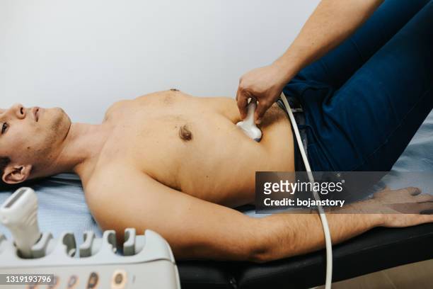junger männlicher patient mit ultraschalluntersuchung des bauches in der medizinischen klinik - appendix stock-fotos und bilder