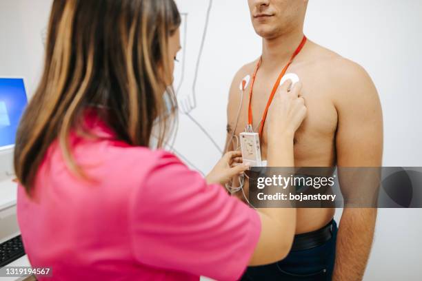 preparing young male patient for heart stress test on treadmill - stress test stock pictures, royalty-free photos & images