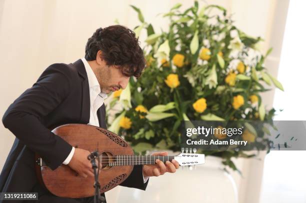 Mandolin player Avi Avital performs during a special naturalization ceremony held at Bellevue presidential palace in recognition of the 72nd...