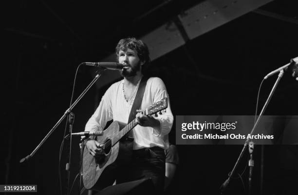 American singer-songwriter and actor Kris Kristofferson, wearing a white v-neck top, playing an acoustic guitar as he performs live at the Schaefer...