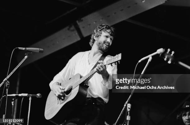 American singer-songwriter and actor Kris Kristofferson, wearing a white v-neck top, playing an acoustic guitar as he performs live at the Schaefer...