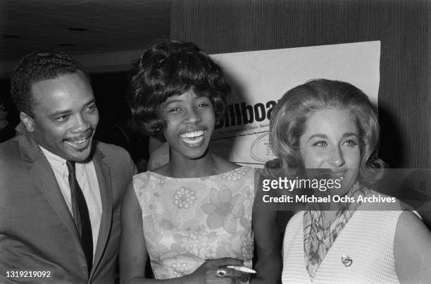 American record producer, musician and songwriter Quincy Jones, wearing a suit with a shirt and tie, Jamaican singer-songwriter Millie Small ,...