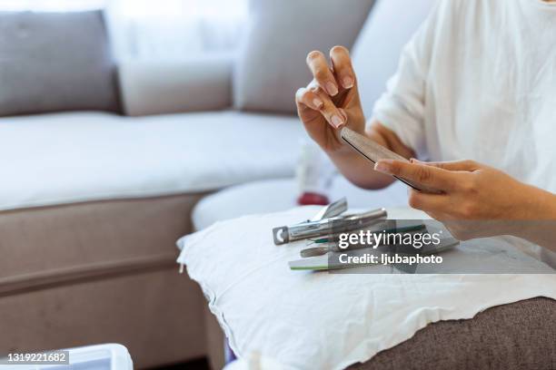 woman having manicure treatment in bedroom - nail file stock pictures, royalty-free photos & images