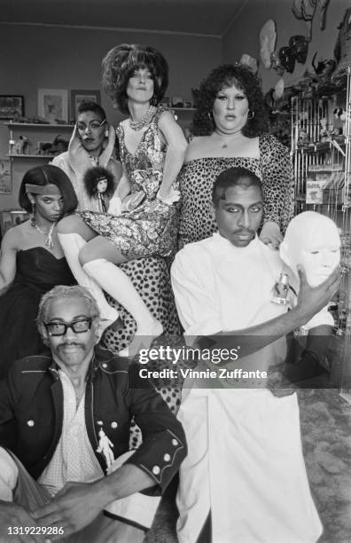 Group of young people dressed in New Wave fashions, with a young man wearing heavy rimmed glasses, a black jacket with a white silhouette of a...