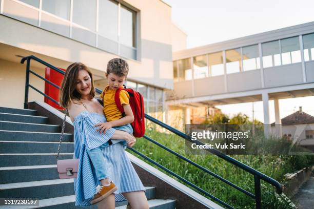 mother picking up her son from the school - picking up child stock pictures, royalty-free photos & images
