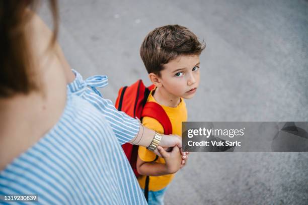 mother holding her son's hand sending him to school - butterflies in the stomach stock pictures, royalty-free photos & images