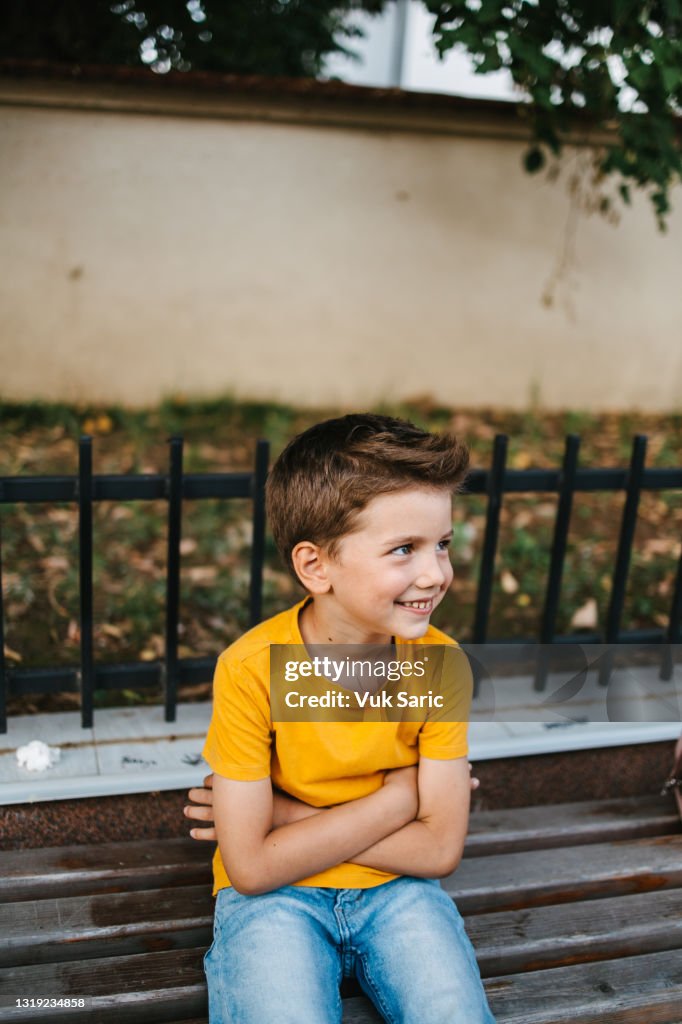 Écolier assis sur le banc souriant