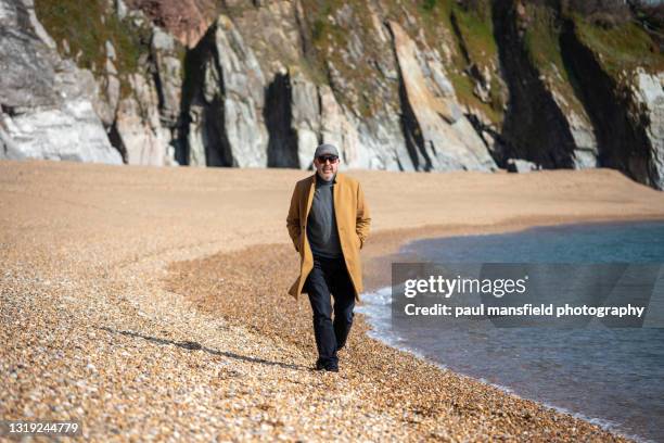 man in camel coat at devon coast - long coat stock pictures, royalty-free photos & images