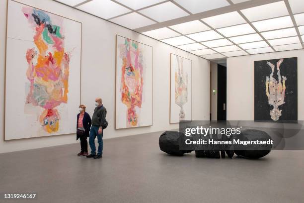 Visitors wearing face masks during the exhibition of Georg Baselitz at the Pinakothek der Moderne on May 21, 2021 in Munich, Germany. Museum and...