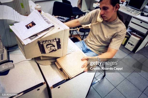 Journalist works next to a poster with the phrase 'Do not forget Cabezas' and photo of murdered photographer Jose Luis Cabezas pasted on a computer's...