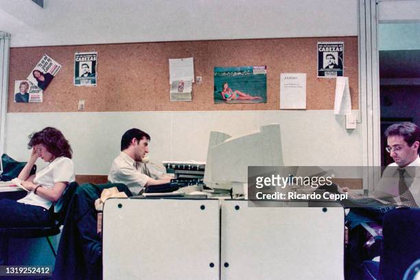 Journalists work next to posters of the murdered photographer Jose Luis Cabezas at the editorial offices of the Noticias magazine on May 18 in Buenos...