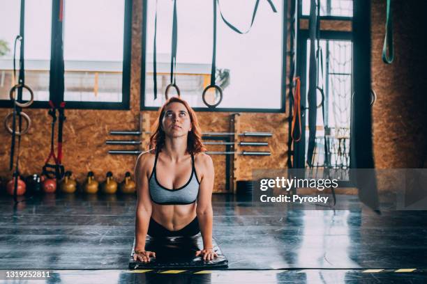 female athlete doing stretching exercises - cobra stretch stock pictures, royalty-free photos & images