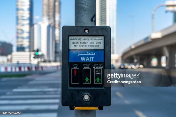 pedestrian crossing button on dubai street - pedestrian crossing sign stock-fotos und bilder