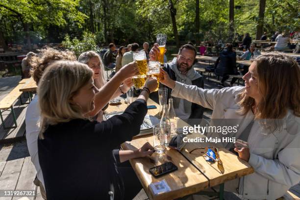 First guest sit outside a Biergarten "Café am Neuen See" and drink beer for the first time this year during the coronavirus pandemic on May 21, 2021...