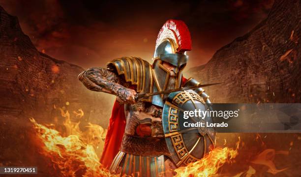 a senior bearded warrior gladiator holding a fiery weapon - fight for the troops stock pictures, royalty-free photos & images