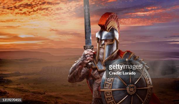 un gladiador guerrero barbudo de alto rango sosteniendo un arma ardiente - armadura fotografías e imágenes de stock