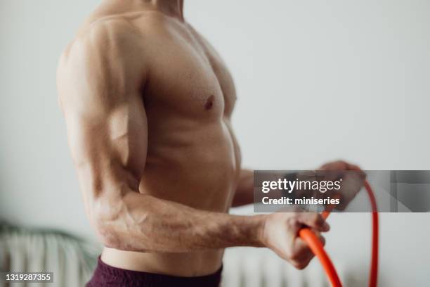 unrecognizable man exercising at home using resistance band - bicep stretch stock pictures, royalty-free photos & images