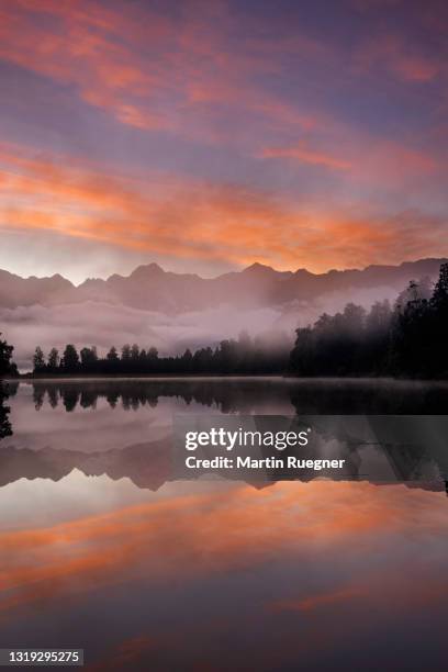 lake matheson with mount cook and mount tasman reflecting in water at sunrise, south island, new zealand. - lake matheson new zealand stock pictures, royalty-free photos & images