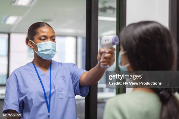 checking for a fever - infection control stock pictures, royalty-free photos & images