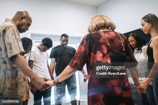 extended family reuniting together for prayer - christianity stock pictures, royalty-free photos & images