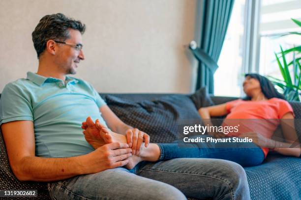 husband giving a foot massage to pregnant  wife - swollen ankles stock pictures, royalty-free photos & images