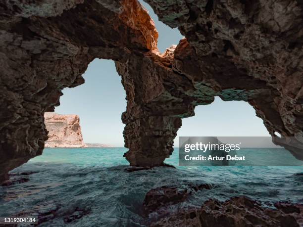 beautiful natural arches cave in the spanish coast with the mediterranean sea. cueva con vistas al mar en la costa blanca de alicante. - rock formation landscape stock pictures, royalty-free photos & images