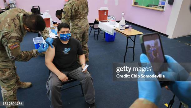 Man asks for his photo to be taken while Maryland National Guard Specialist James Truong administers his Moderna coronavirus vaccine at CASA de...