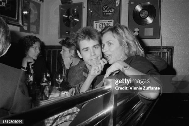 Canadian-American actor and comedian Jim Carrey and American model and actress Lauren Hutton in the booth of a restaurant with Elvis Presley...