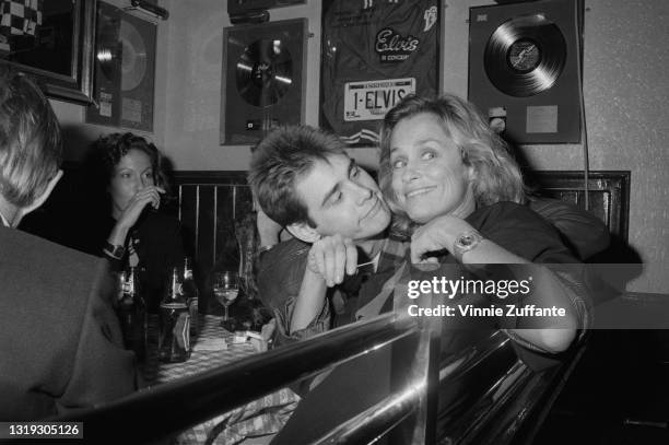 Canadian-American actor and comedian Jim Carrey and American model and actress Lauren Hutton in the booth of a restaurant with Elvis Presley...