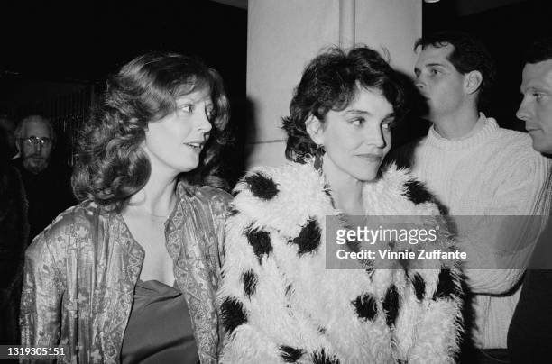 American actress Susan Sarandon, wearing a silk jacket, and American actress Brooke Adams, wearing a shaggy white fur coat with black spots,...