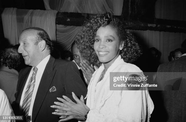 American record producer and music industry executive Clive Davis with American singer and actress Whitney Houston , attend an unspecified event,...