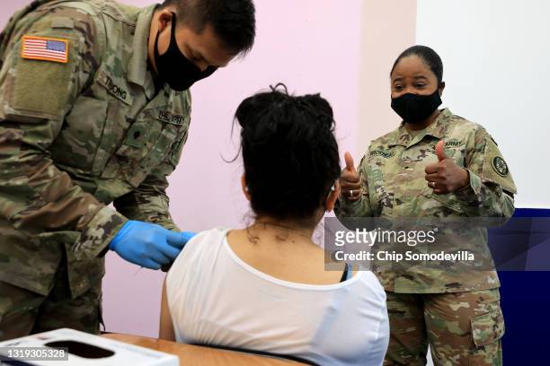 Maryland National Guard Brigadier General Janeen Birckhead visits with a woman as she receives her Moderna coronavirus vaccine from Specialist James...