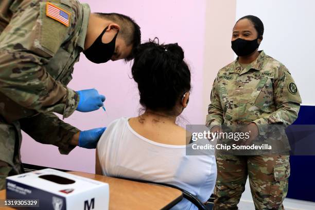 Maryland National Guard Brigadier General Janeen Birckhead visits with a woman as she receives her Moderna coronavirus vaccine from Specialist James...