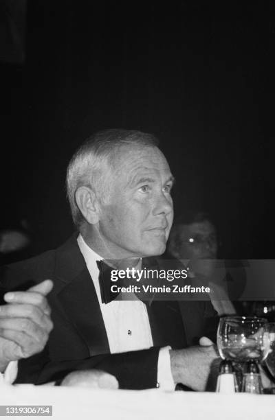 American television presenter and comedian Johnny Carson , wearing a tuxedo and bow tie, attends the Friars Club ceremony where Burt Reynolds was...