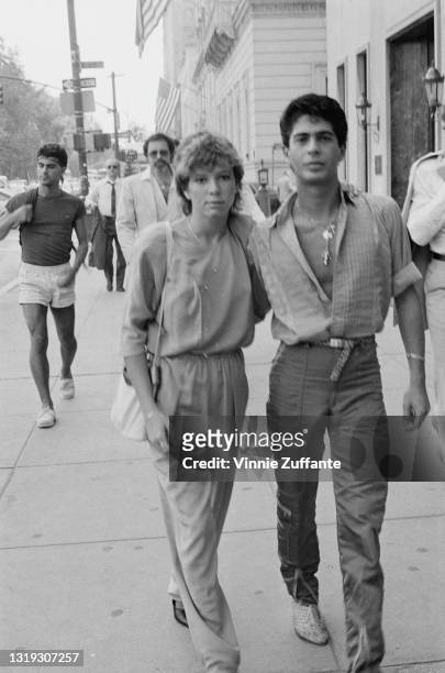 American actress and comedian Kristy McNichol with her arm around hairdresser Joey Corsaro as they walk along an unspecified street, location...