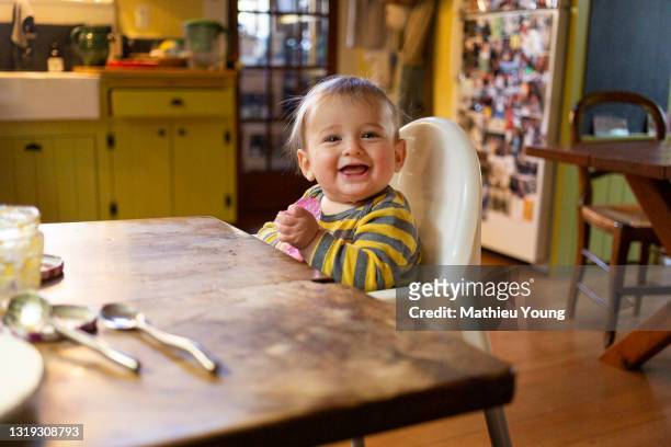 baby at kitchen table - kauen stock-fotos und bilder