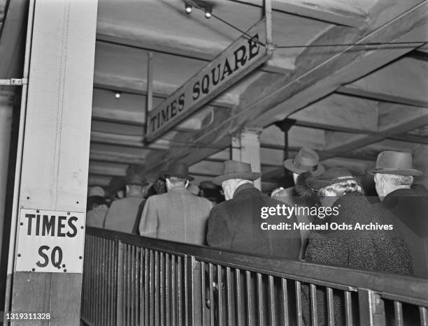 Crowds leaving a platform, beneath a 'Times Square' sign, at Times Square New York City Subway Station, Times Square in the Manhattan borough of New...