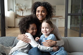 Portrait of biracial mom relax with multiethnic daughters