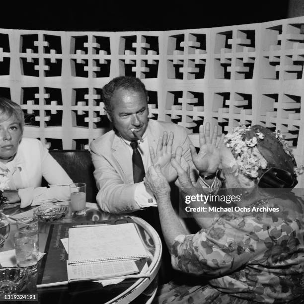 Fortune teller reading the palms of an unspecified guest attending a party held at the Beverly Hills Hotel on Sunset Boulevard in Beverly Hills,...